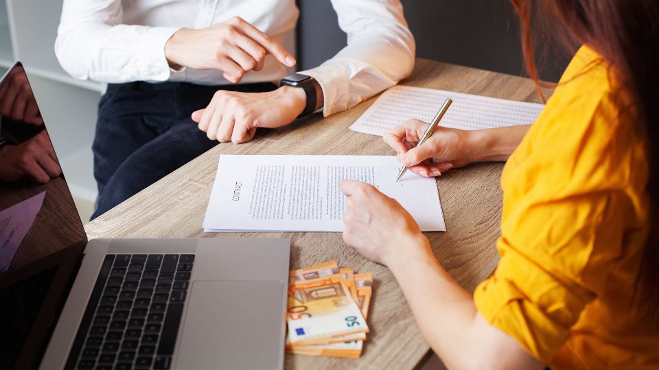 Une femme signant un contrat pour un prêt relais